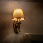 Vintage wall sconce casting a warm and cozy glow in an indoor setting, perfect for ambiance.