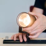 A female engineer testing a light fixture prototype in an office setting, showcasing innovation.